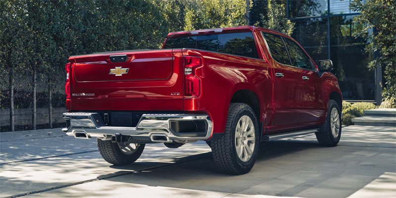 Red Chevrolet Silverado 1500 pickup truck rear view.